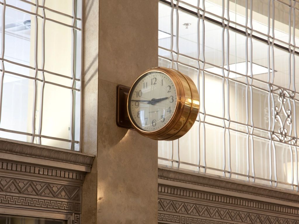 A brass clock on a stone column